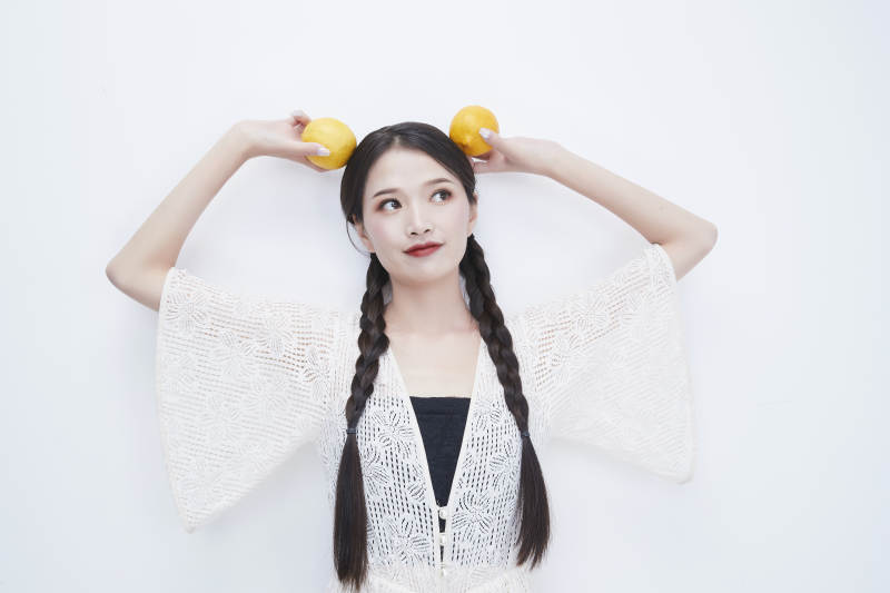 头顶柠檬身穿镂空连衣裙的亚洲可爱少女人像图片