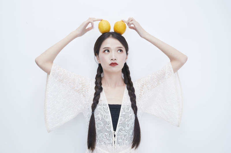 头顶柠檬身穿镂空连衣裙的亚洲可爱少女人像图片