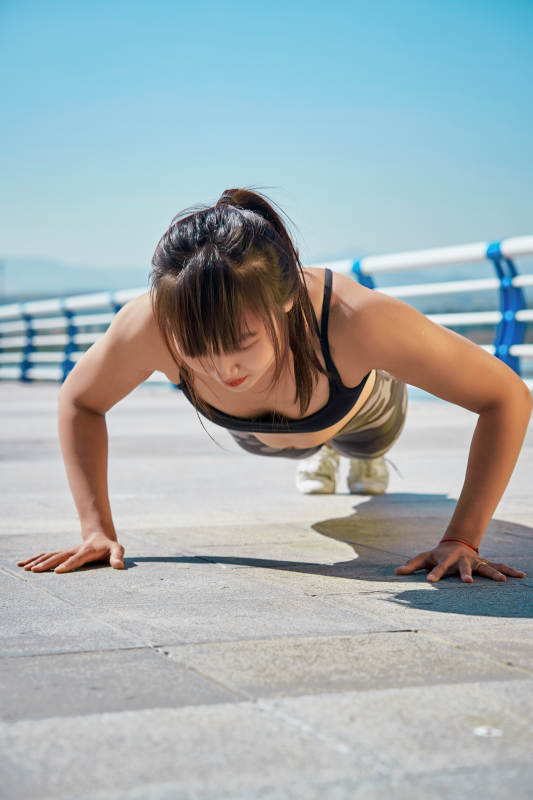 户外河畔公园做拉伸有氧运动的亚洲女性图片