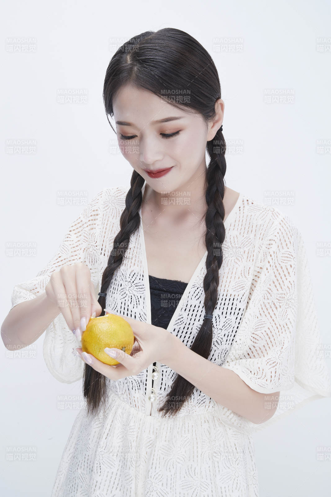 在剥橙子皮的身穿镂空连衣裙的亚洲少女人像图片