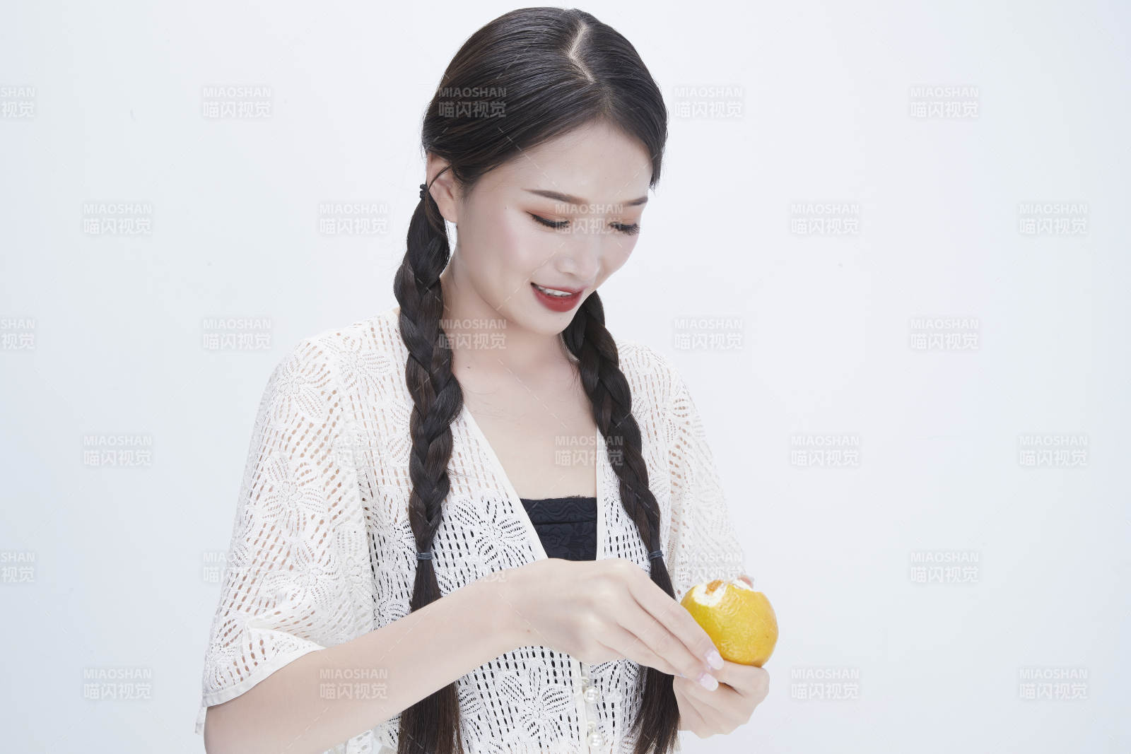 在剥橙子皮的身穿镂空连衣裙的亚洲少女人像图片