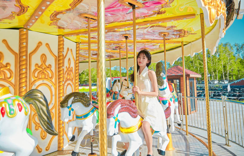 在游乐园坐旋转木马的可爱少女图片