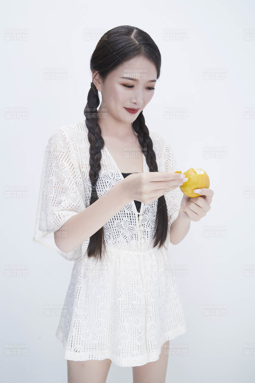 在剥橙子皮的身穿镂空连衣裙的亚洲少女人像图片