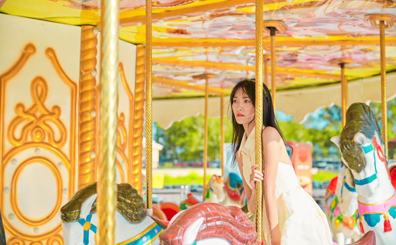 在游乐园坐旋转木马的可爱少女图片