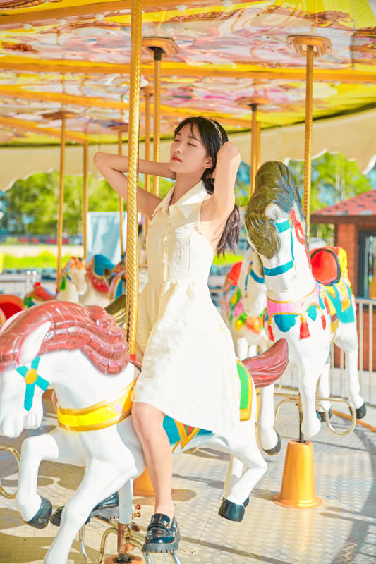 在游乐园坐旋转木马的可爱少女图片