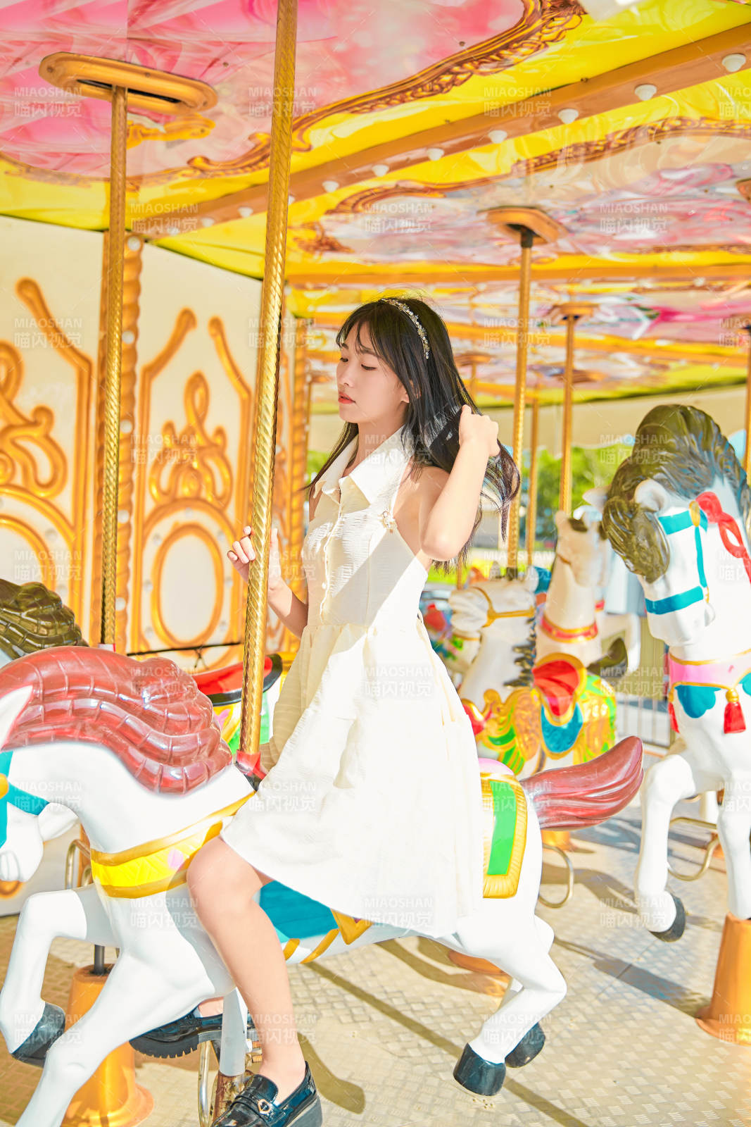 在游乐园坐旋转木马的可爱少女图片