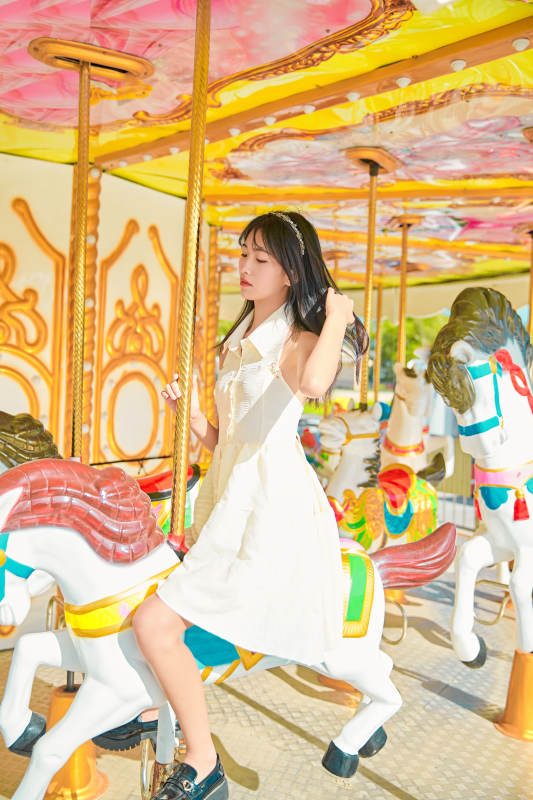 在游乐园坐旋转木马的可爱少女图片
