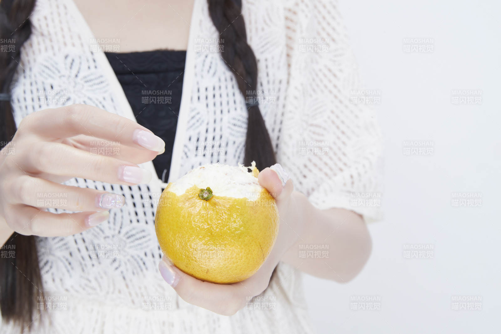 在剥橙子皮的身穿镂空连衣裙的亚洲少女人像图片