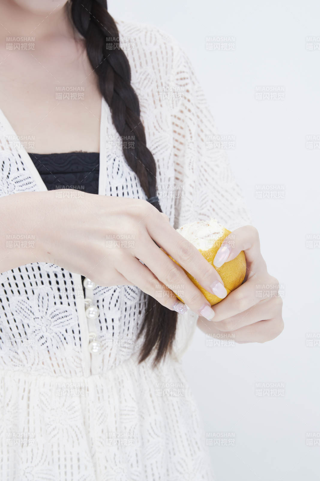 在剥橙子皮的身穿镂空连衣裙的亚洲少女人像图片