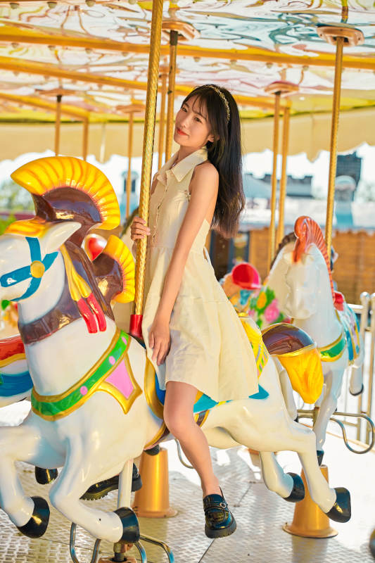在游乐园坐旋转木马的可爱少女图片