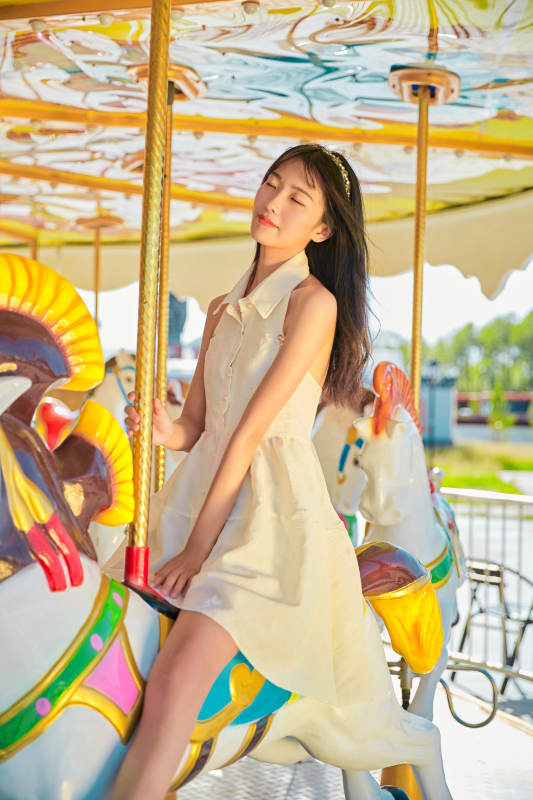 在游乐园坐旋转木马的可爱少女图片