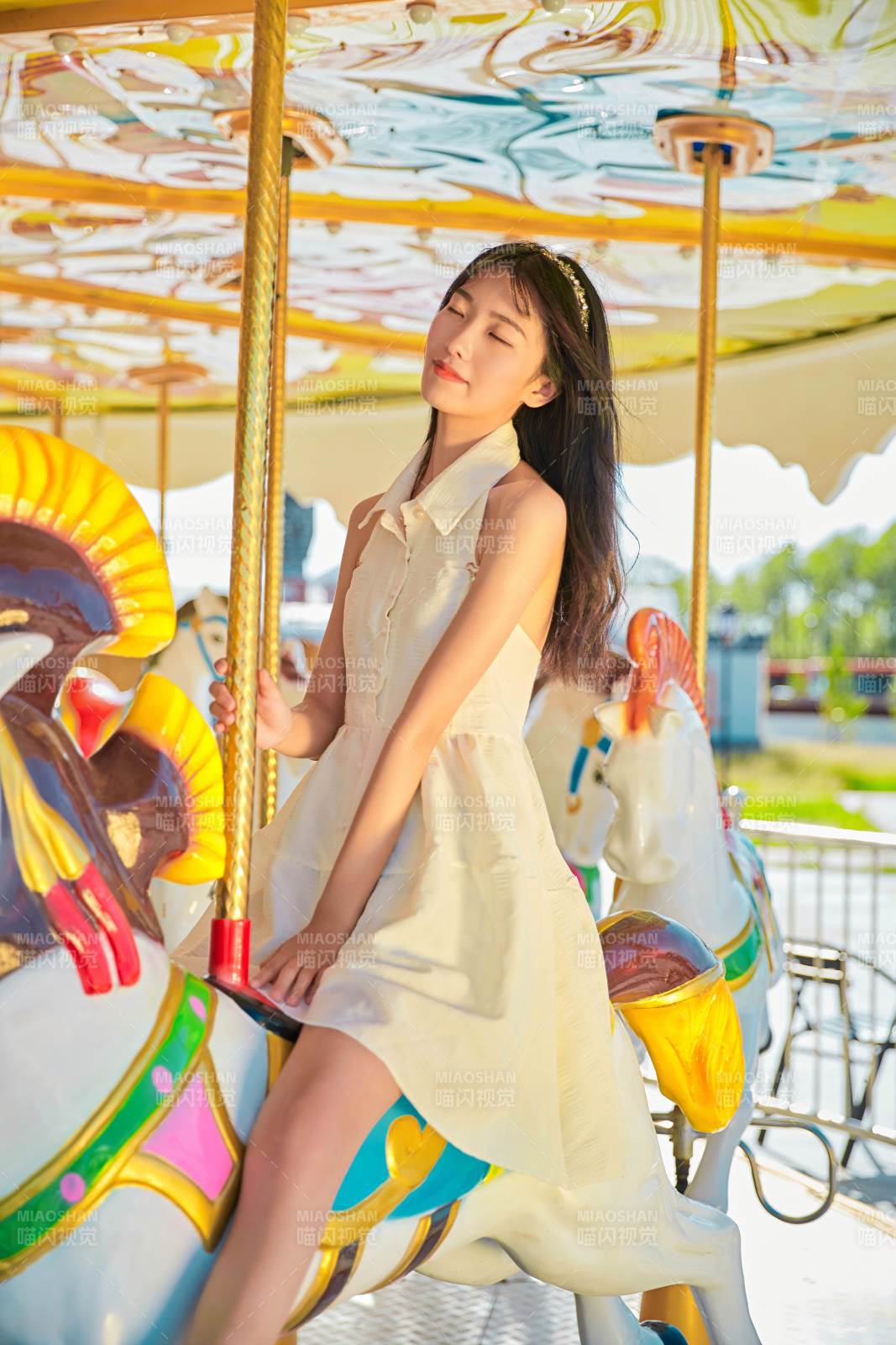 在游乐园坐旋转木马的可爱少女图片