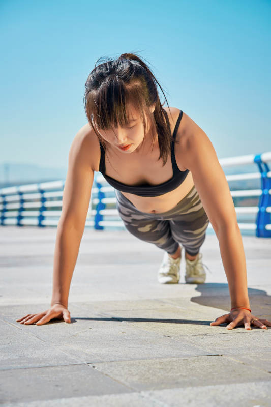 户外河畔公园做拉伸有氧运动的亚洲女性图片