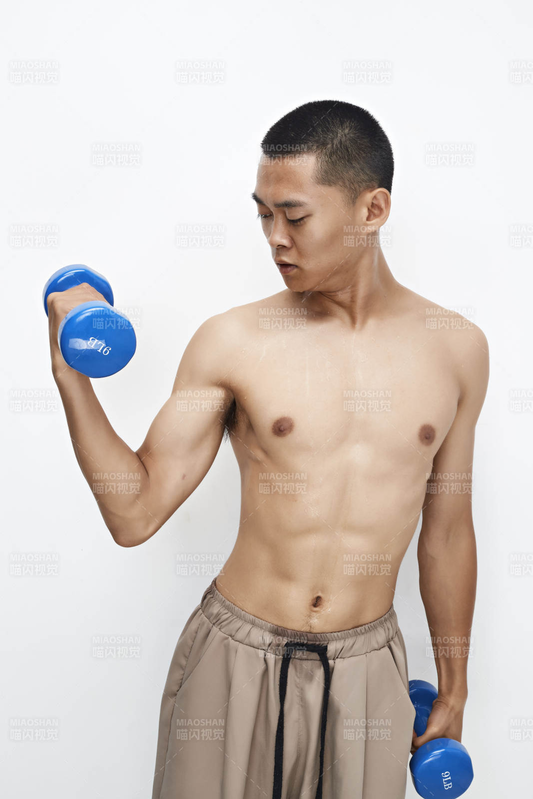 使用哑铃进行健身锻炼的亚洲男性图片