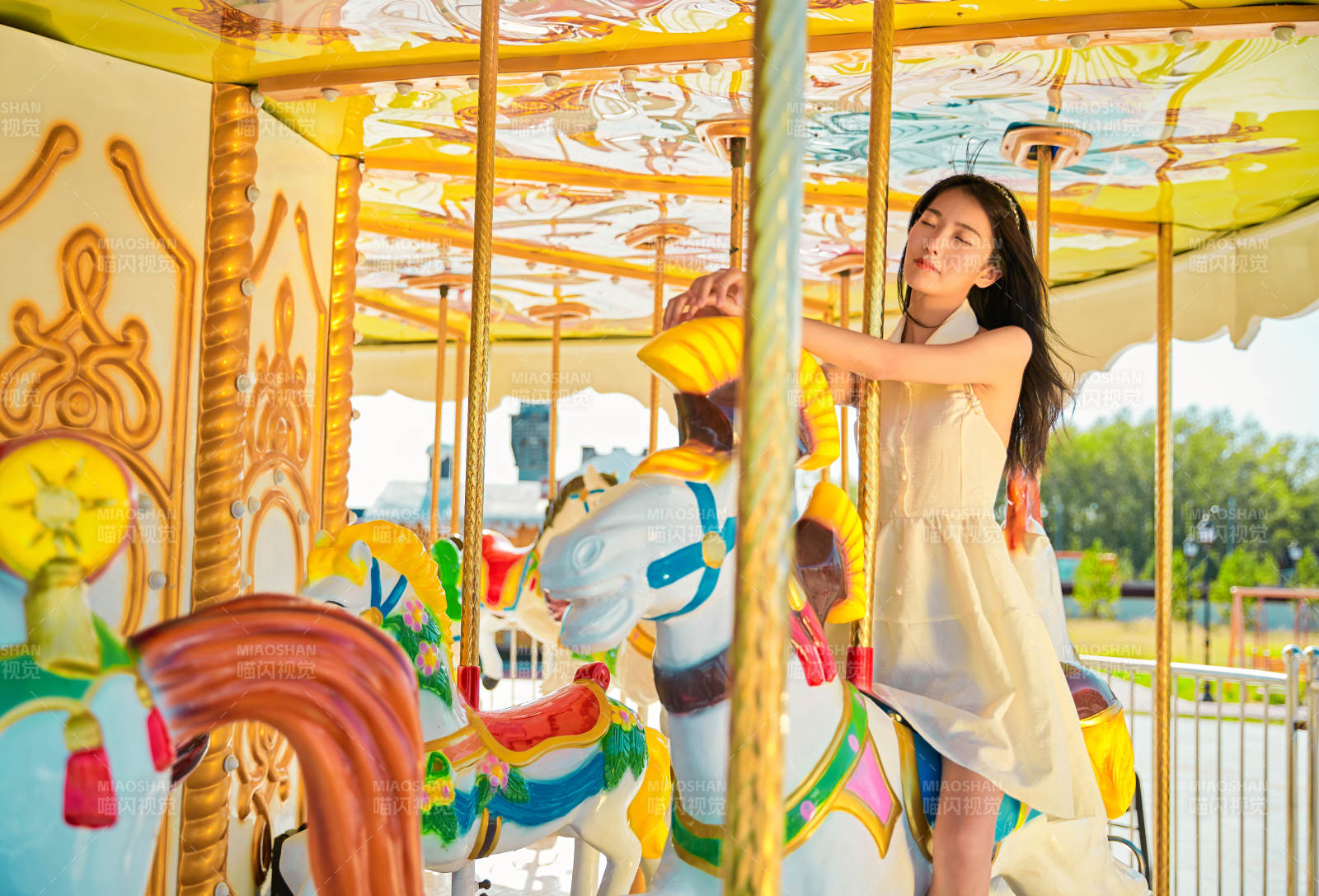在游乐园坐旋转木马的可爱少女图片