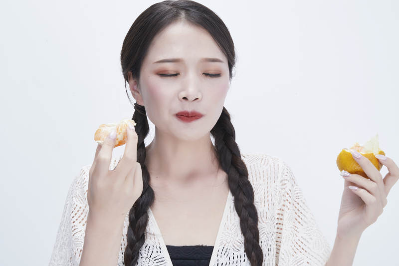 吃橙子被酸到的身穿镂空连衣裙可爱少女人像图片