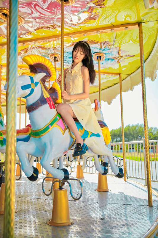 在游乐园坐旋转木马的可爱少女图片