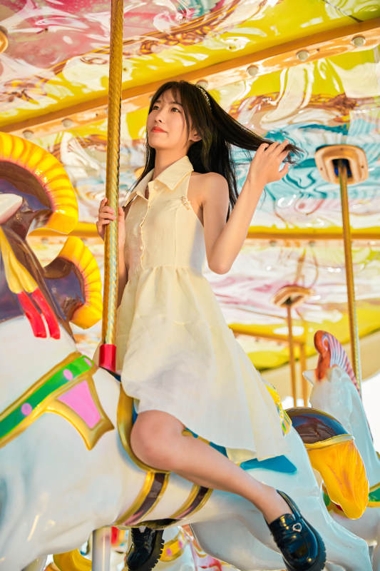在游乐园坐旋转木马的可爱少女图片