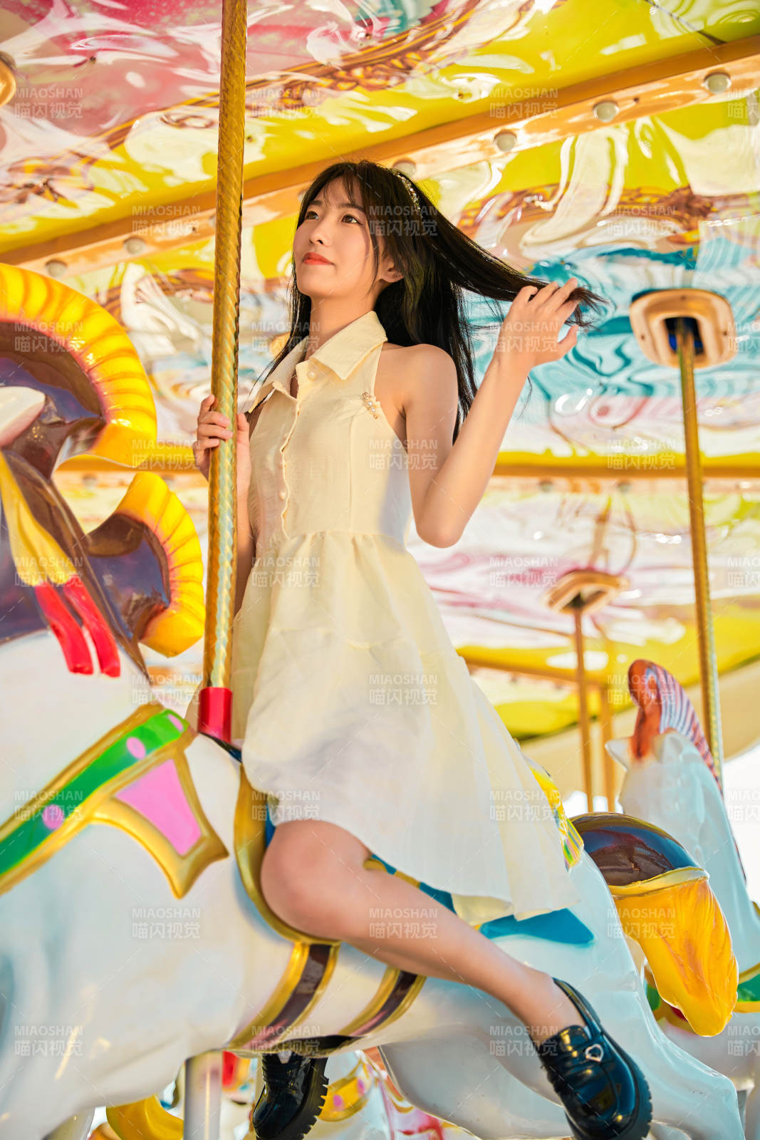 在游乐园坐旋转木马的可爱少女图片