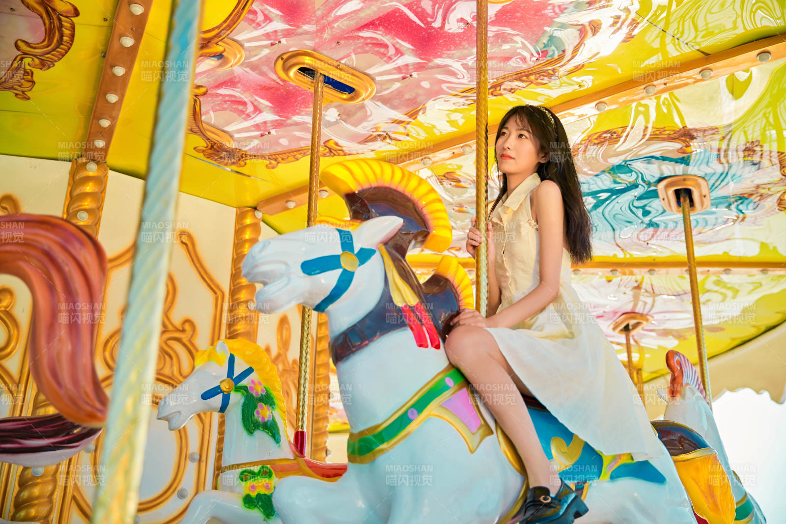 在游乐园坐旋转木马的可爱少女图片