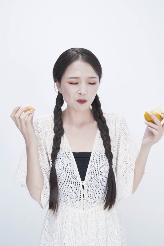 吃橙子被酸到的身穿镂空连衣裙可爱少女人像图片