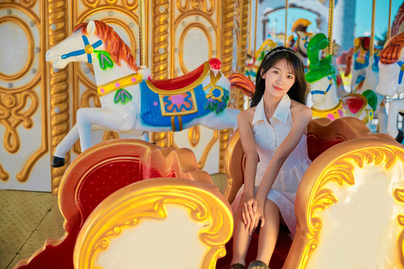 在游乐园坐旋转木马的可爱少女图片