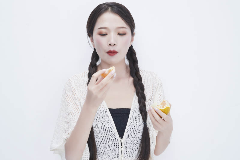 吃橙子被酸到的身穿镂空连衣裙可爱少女人像图片