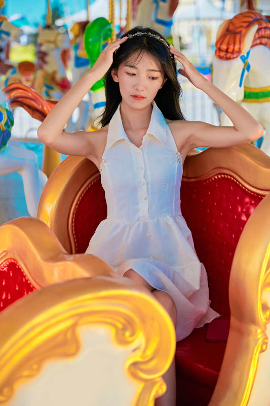 在游乐园坐旋转木马的可爱少女图片