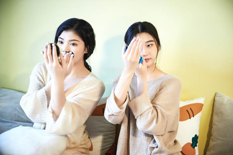 坐在床上化妆玩耍的俩位美女图片