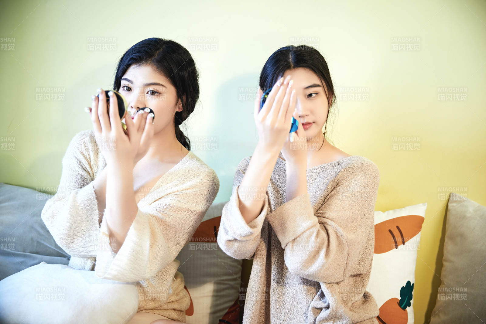 坐在床上化妆玩耍的俩位美女图片