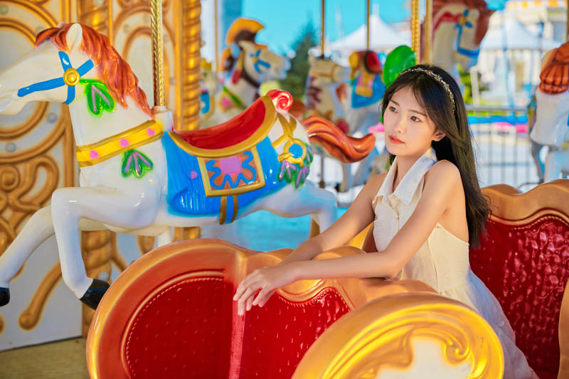 在游乐园坐旋转木马的可爱少女图片