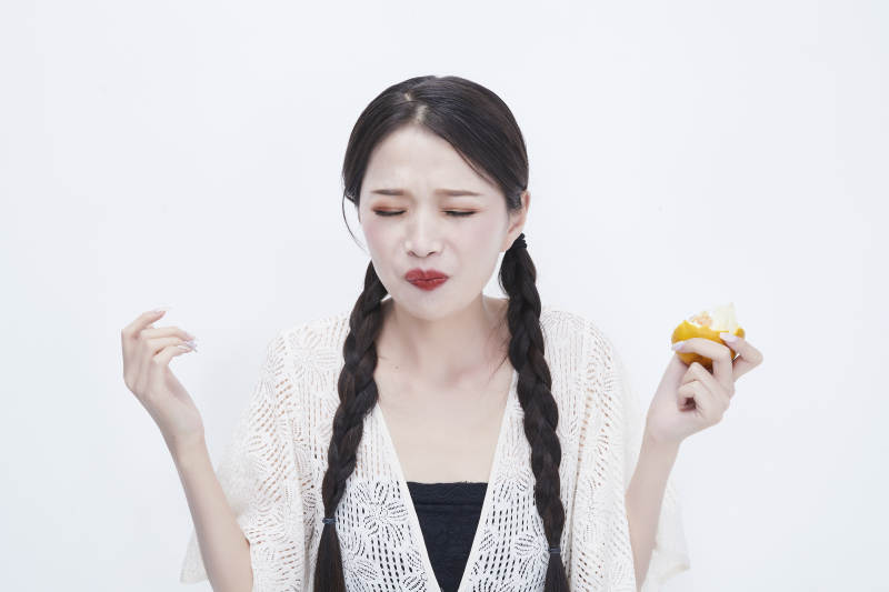 吃橙子被酸到的身穿镂空连衣裙可爱少女人像图片