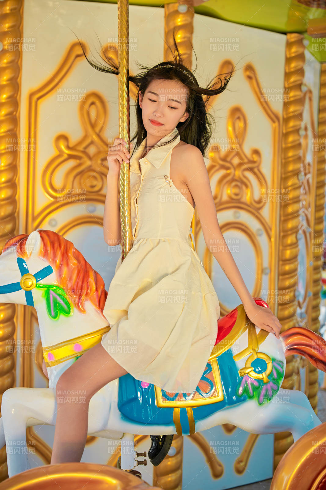 在游乐园坐旋转木马的可爱少女图片