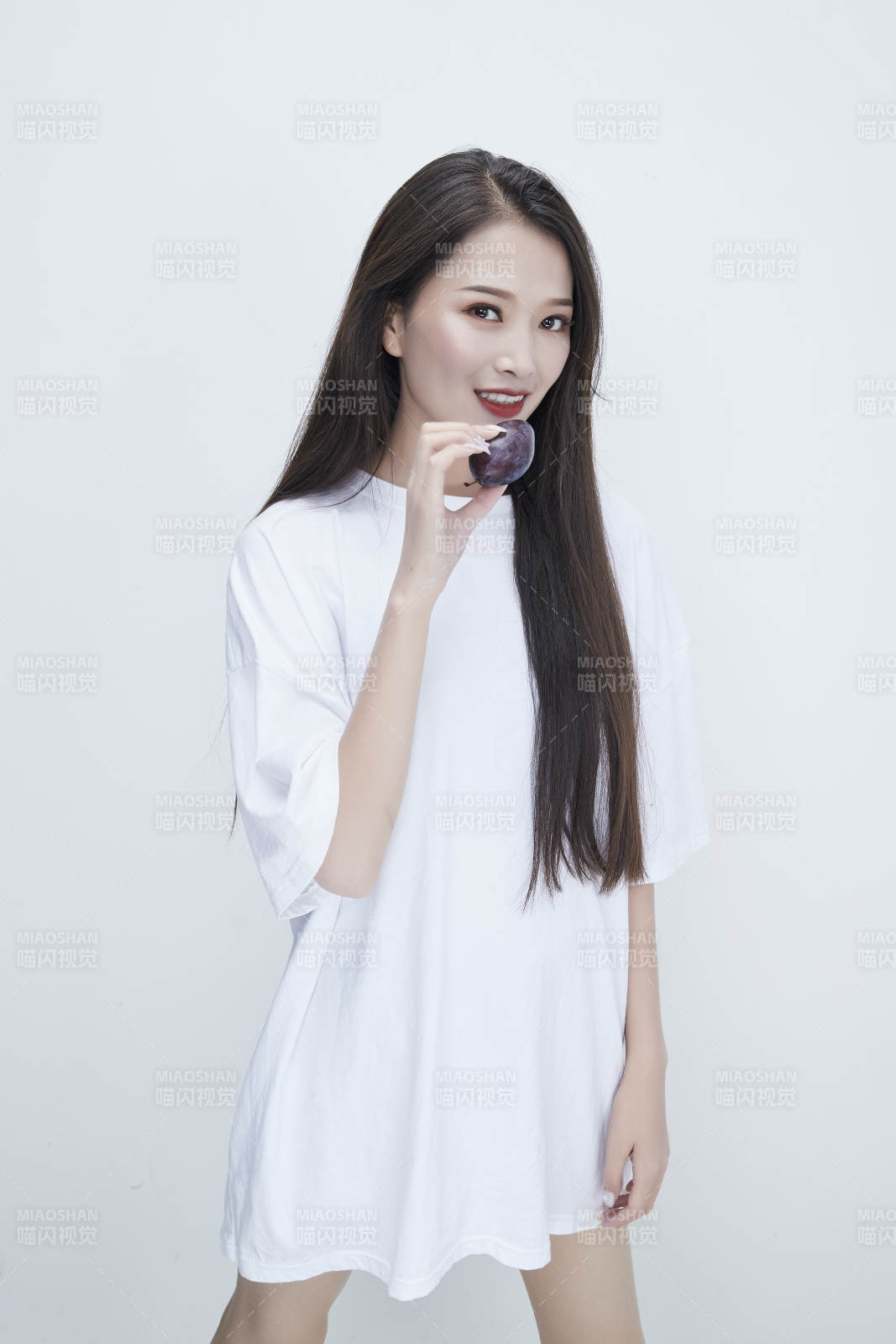 吃西梅的身穿白色长T血衬衫的长发少女人像图片