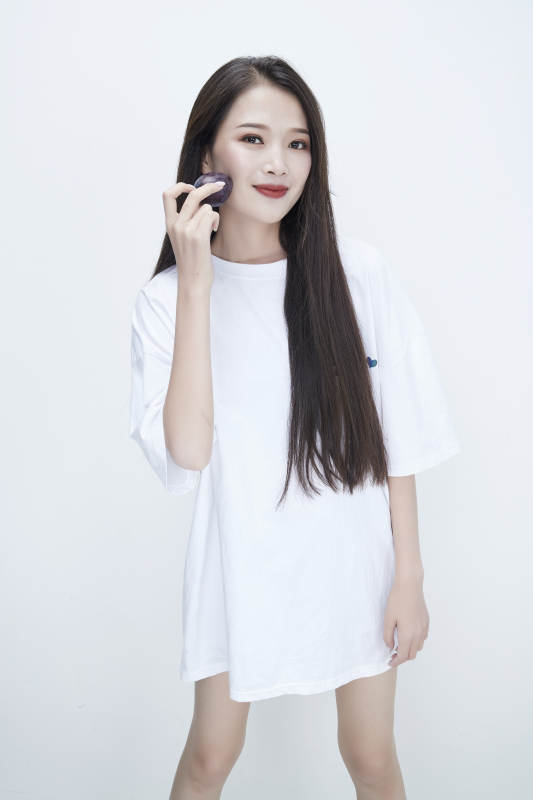 吃西梅的身穿白色长T血衬衫的长发少女人像图片