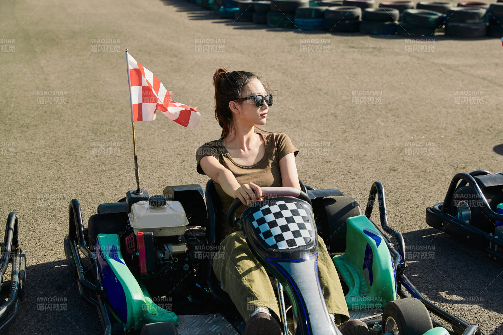 在游乐场卡丁赛道上驾驶卡丁车的美女图片