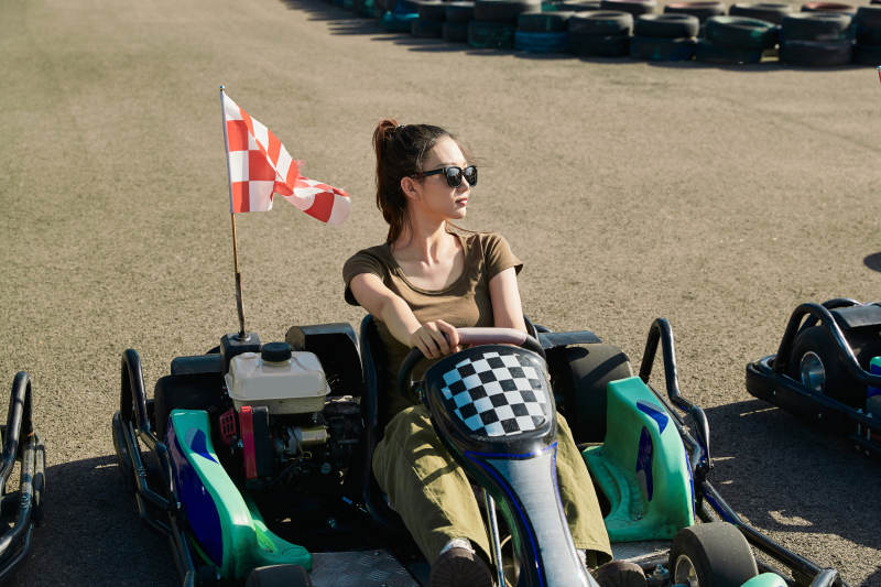 在游乐场卡丁赛道上驾驶卡丁车的美女图片