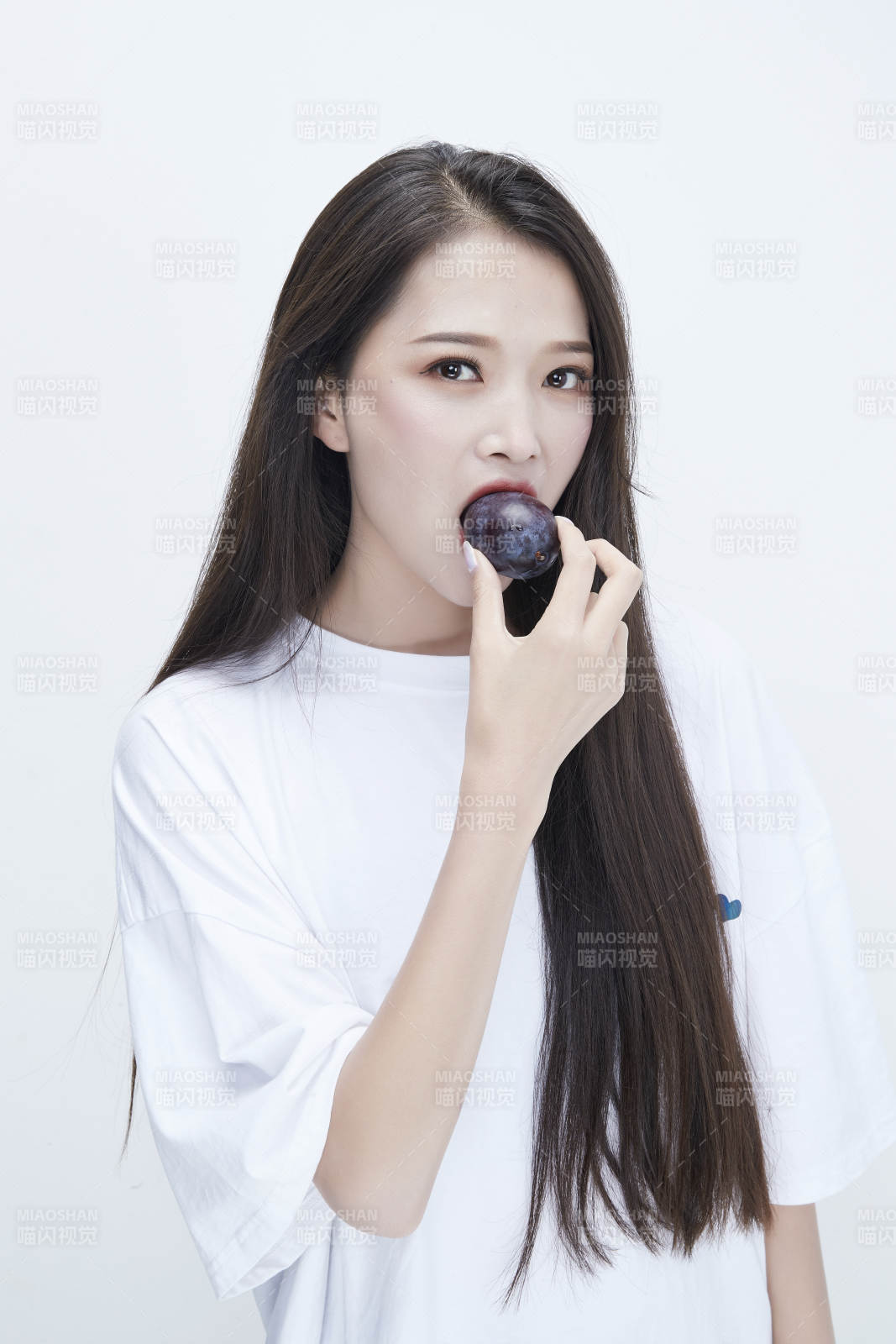 吃西梅的身穿白色长T血衬衫的长发少女人像图片