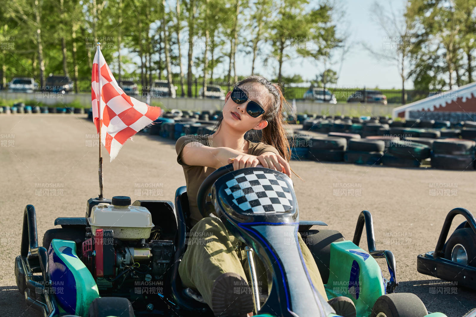 在游乐场卡丁赛道上驾驶卡丁车的美女图片