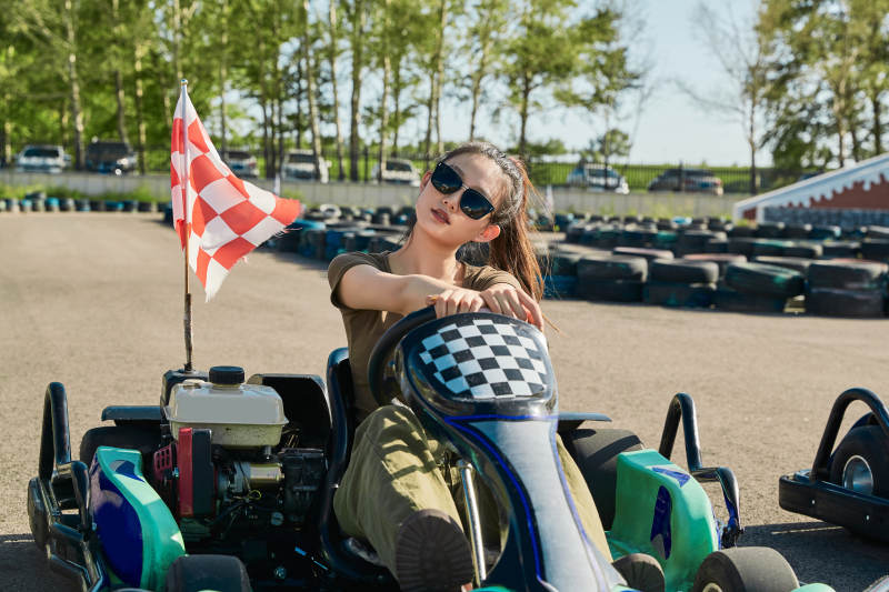 在游乐场卡丁赛道上驾驶卡丁车的美女图片
