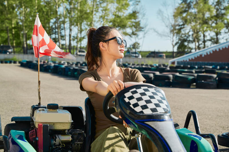 在游乐场卡丁赛道上驾驶卡丁车的美女图片