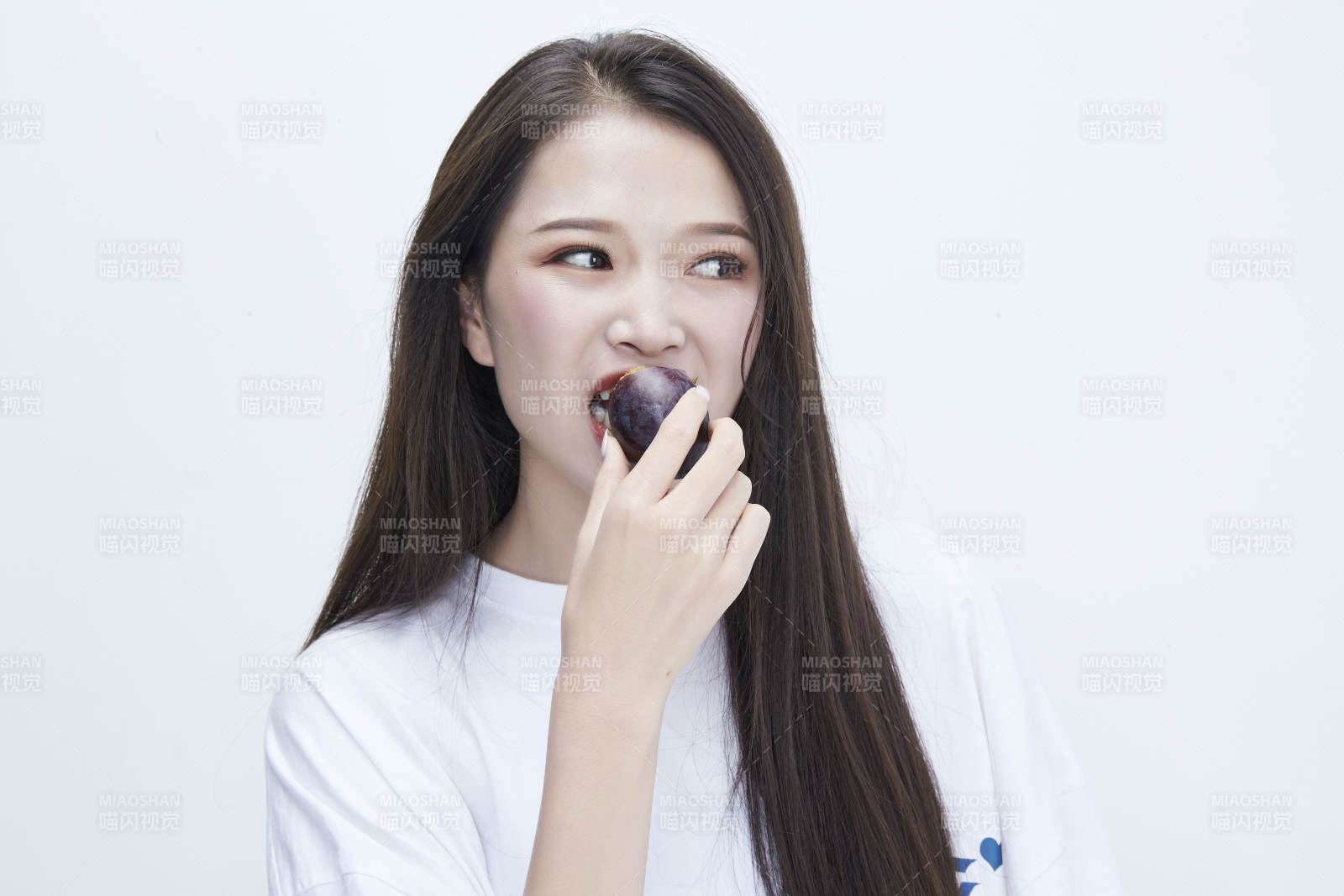 吃西梅的身穿白色长T血衬衫的长发少女人像图片