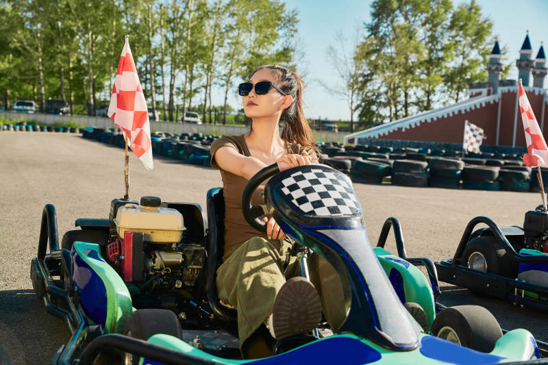 在游乐场卡丁赛道上驾驶卡丁车的美女图片
