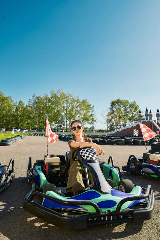 在游乐场卡丁赛道上驾驶卡丁车的美女图片