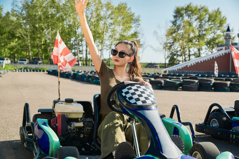 在游乐场卡丁赛道上驾驶卡丁车的美女图片