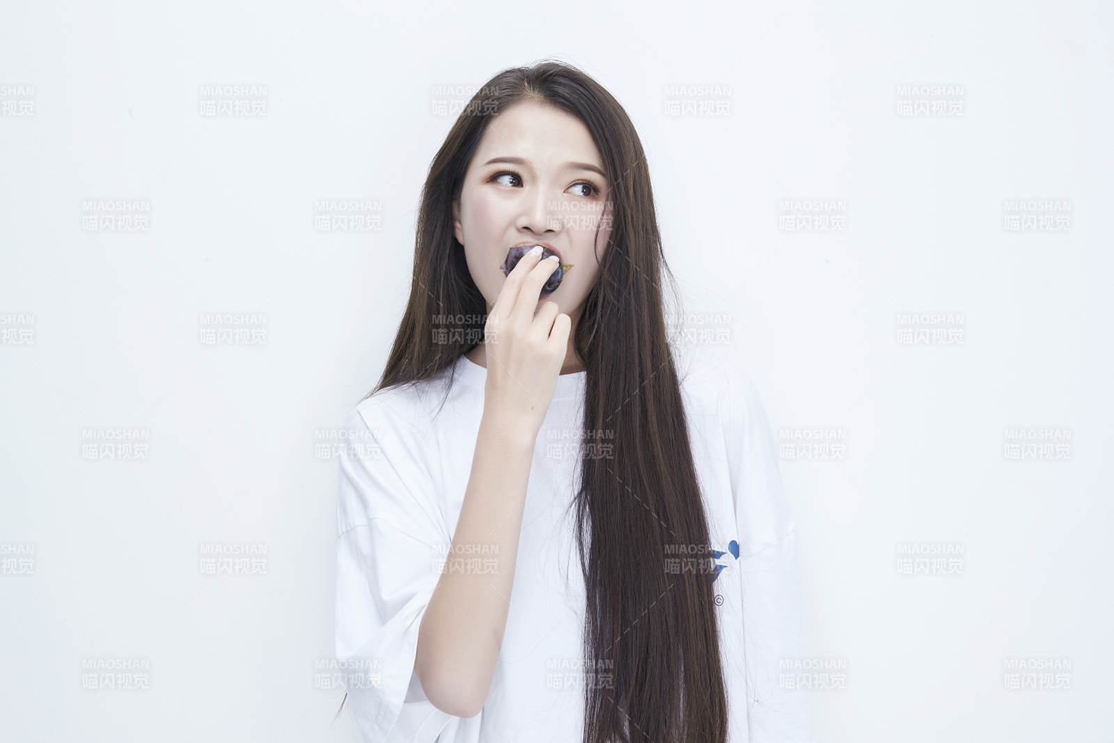 吃西梅的身穿白色长T血衬衫的长发少女人像图片