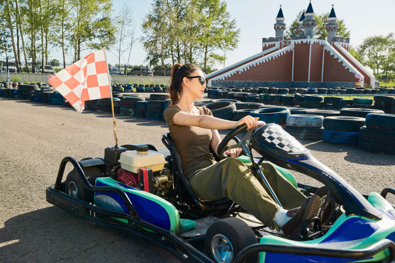 在游乐场卡丁赛道上驾驶卡丁车的美女图片