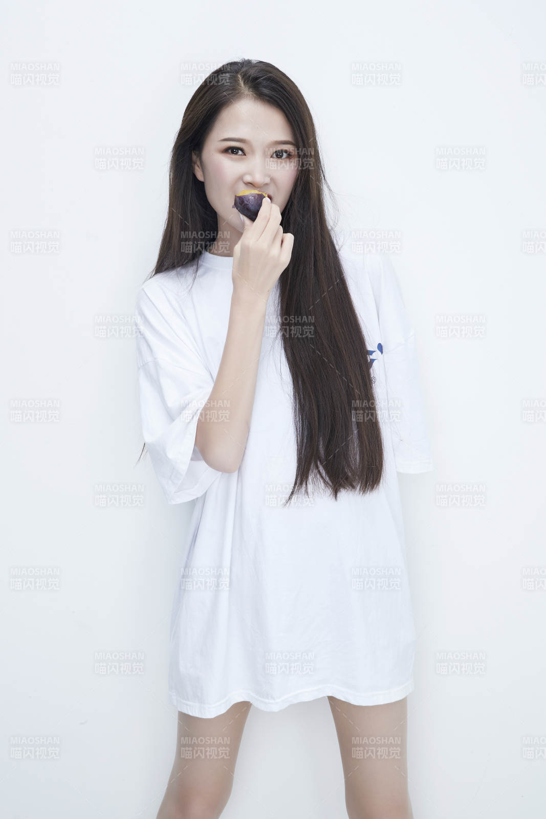 吃西梅的身穿白色长T血衬衫的长发少女人像图片
