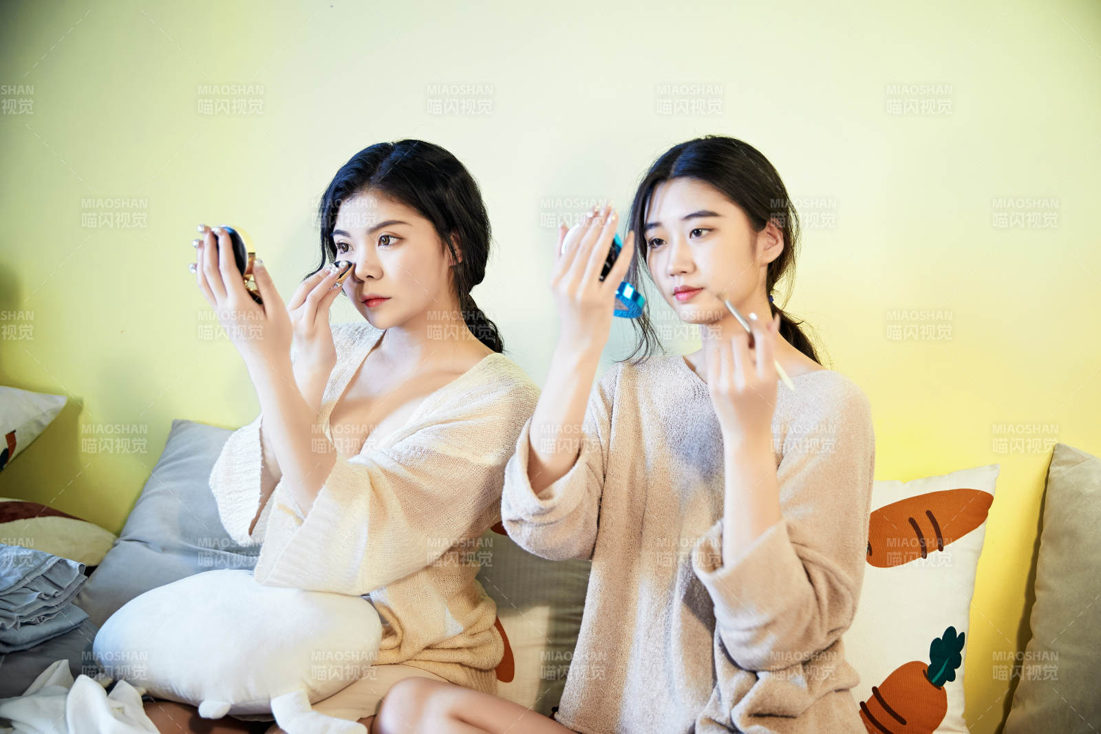 坐在床上化妆玩耍的俩位美女图片