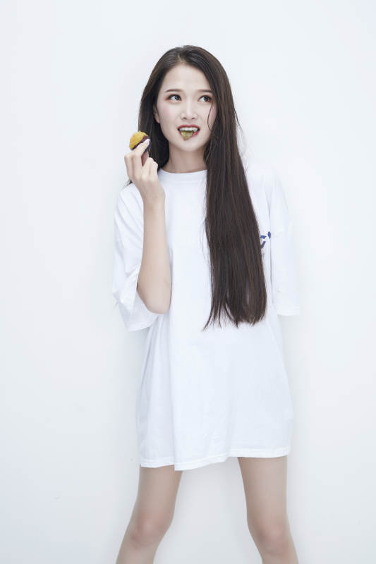 吃西梅的身穿白色长T血衬衫的长发少女人像图片